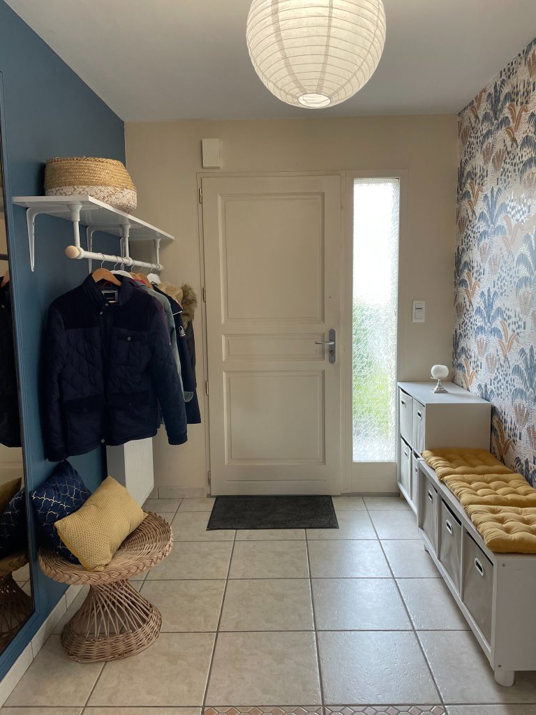 Photo entrée maison avec penderie ouverte sur la gauche et banquette sur la droite